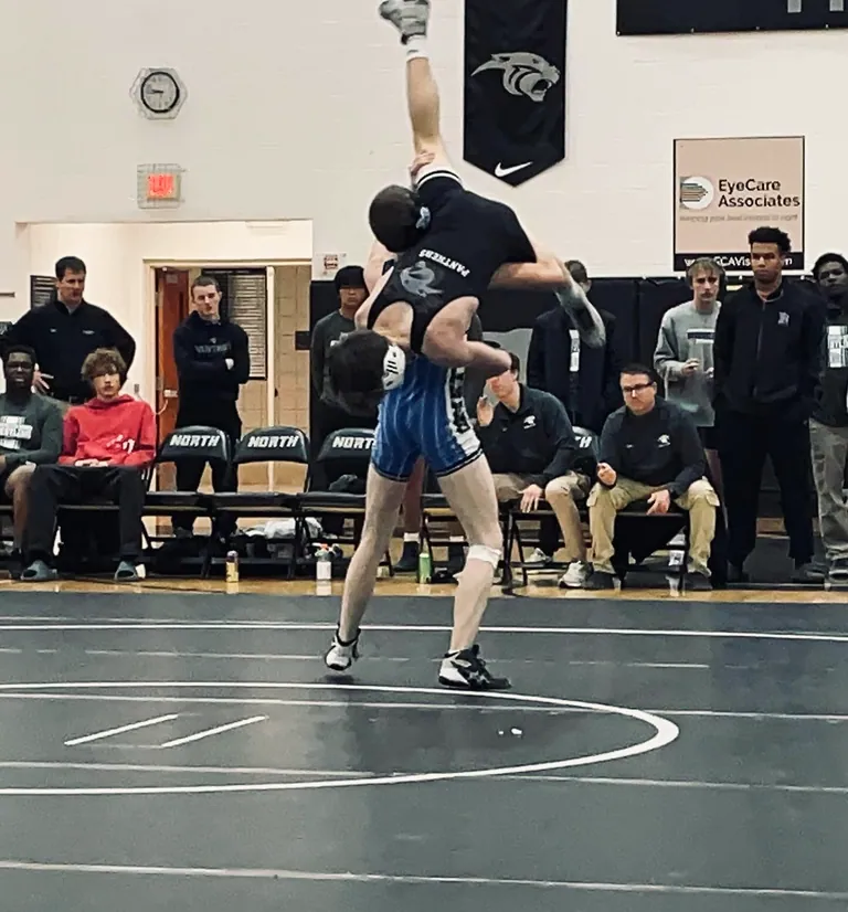 High-school Nathan Johnson lifting an opponent off the mat in a wrestling match