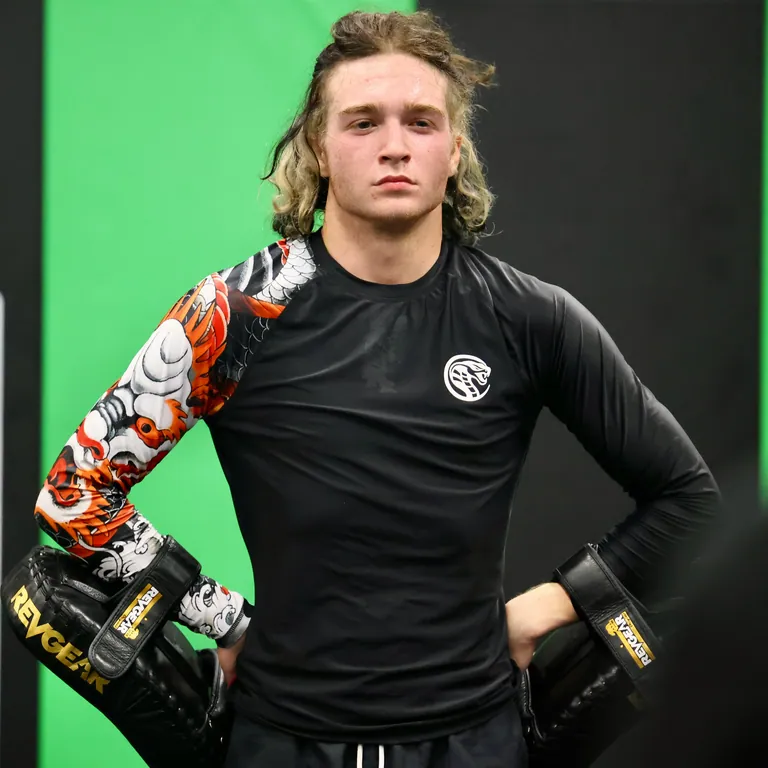 Nathan Johnson, hands on hips, gloves on, in a koi-print rashguard