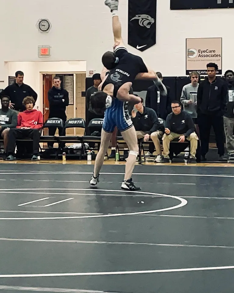 High-school Nathan Johnson lifting an opponent in a wrestling match